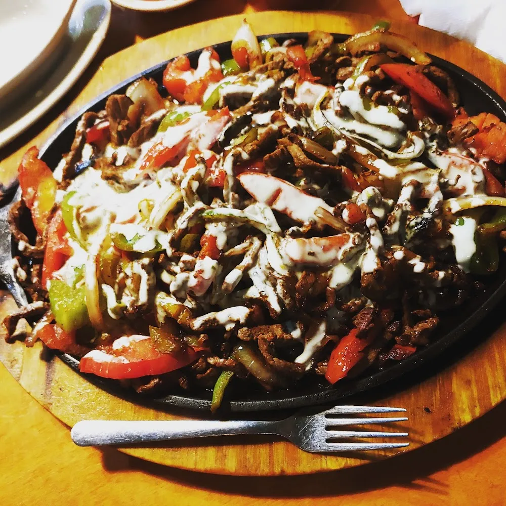 Combination Fajitas with Side of Cheese Sauce Poured on Top